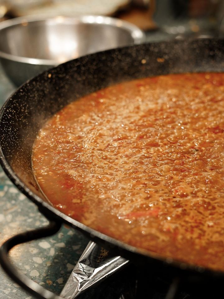Arroz en la paellera durante la cocción
